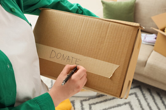 Person labeling a donation box at home