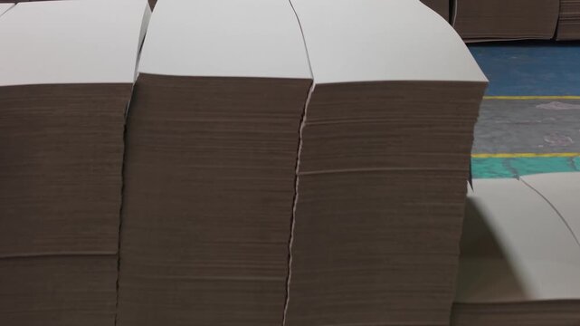 Pilas de cart&oacute;n almacenadas en f&aacute;brica papelera. Materia prima, producci&oacute;n industrial, embalaje, industria del cart&oacute;n, log&iacute;stica, manufactura, reciclaje
