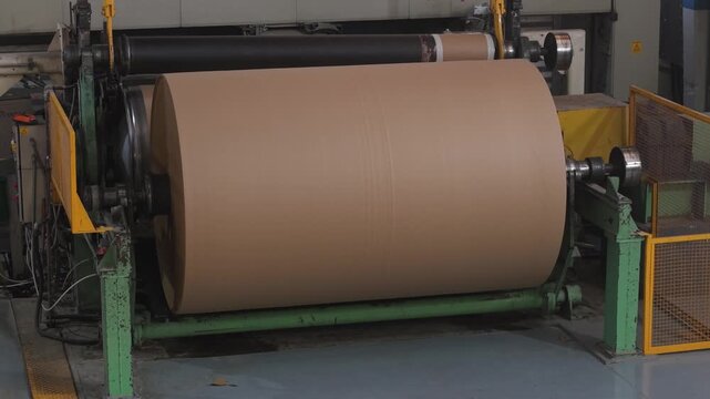 Bobina industrial de papel al final de una m&aacute;quina papelera. Producci&oacute;n de papel reciclado, manufactura, industria papelera, econom&iacute;a circular, tecnolog&iacute;a industrial