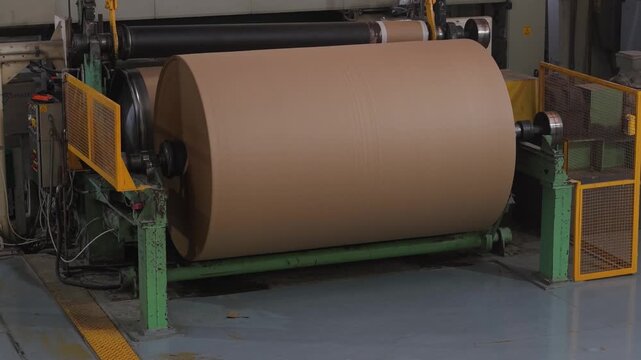 Bobina industrial de papel al final de una m&aacute;quina papelera. Producci&oacute;n de papel reciclado, manufactura, industria papelera, econom&iacute;a circular, tecnolog&iacute;a industrial