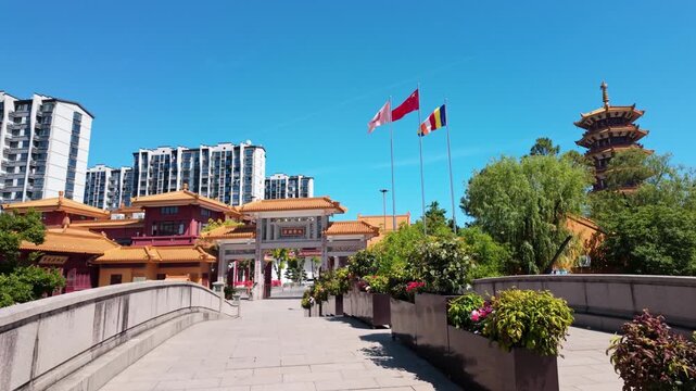 Traditional buddhist temple entrance and pagoda architecture in sunny summer day.