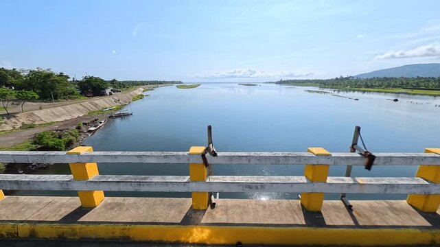 POV driving shot from a side perspective on a bridge, focusing on a faded, moss-covered concrete barrier with ambient engine audio