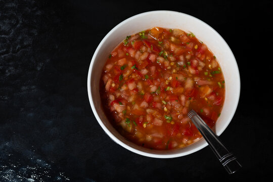 Bowl of fresh pico de gallo salsa on black background