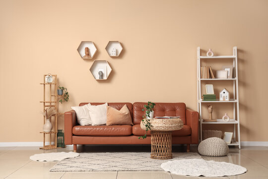 Brown sofa, shelving unit and wicker coffee table in interior of living room