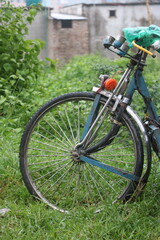 Fototapeta premium Close up of bicycle front wheel and handlebars in grass with handlebar, close