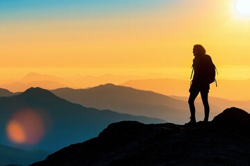 Obraz premium Hiker silhouette standing on a mountain ridge watching a scenic sunset adventure