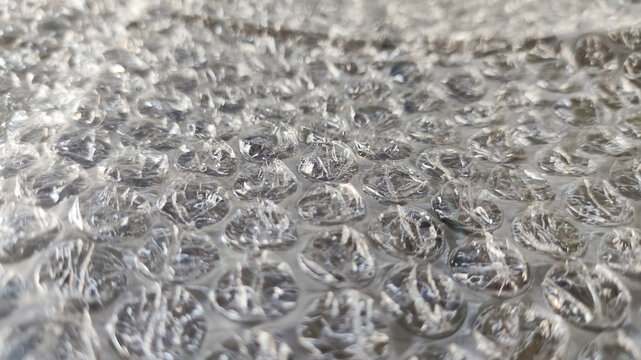Clear plastic bubble wrap ideal for packaging, protective shipping, wrapping fragile items, cushioning delicate goods, creating texture backgrounds in design projects.