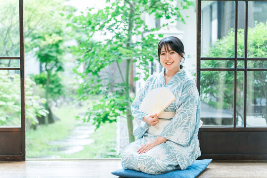 日本家屋の縁側に座る浴衣姿のアジア人女性