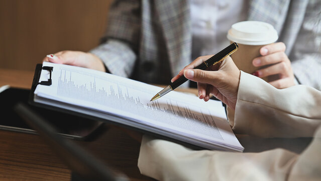 Professional business people discussing or reviewing financial report at office table