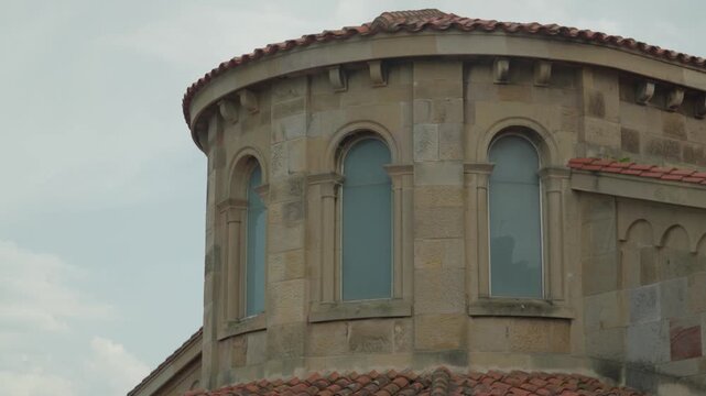 Rounded stone apse and arched windows of Iglesia San Pedro church near Playa San Lorenzo, Gijon.