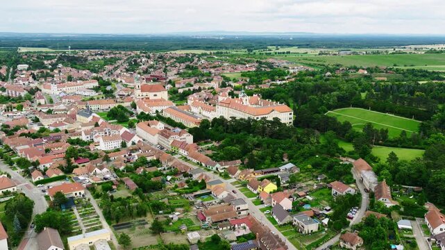 Drone aerial view of Valtice, Czech Republic, featuring the historic town center, magnificent Valtice Castle, surrounding parkland, vineyards, and the UNESCO-listed Lednice&ndash;Valtice Cultural Landscape.