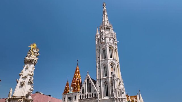 Cinematic sweep across Matthias Church and the Holy Trinity Column in Budapest, Hungary, showcasing Gothic architecture, ornate details, and historic Castle District landmarks.