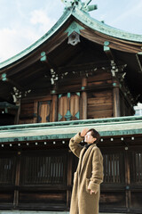 Fototapeta premium 神社の境内で見上げる30代女性の一人旅