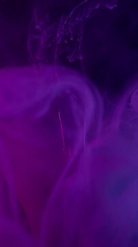 Vertical video. Vapor art. Ink background. Defocused purple blue neon color water cracked light bulb swirling mist spreading on acrylic abstraction.
