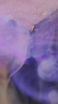 Vertical video. Glitter smoke paint. Blur sparkling flow. Colorful acrylic blob swirl mix on cube. Haze particles violet rainbow fluid abstract background.