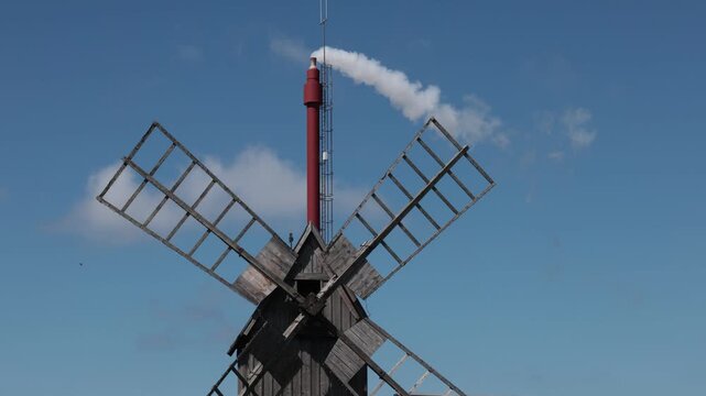 Borgholm, Sweden An old windmill lined up with a smokestack. 