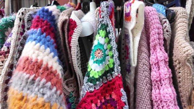 Colorful crochet items displayed in marketplace stalls