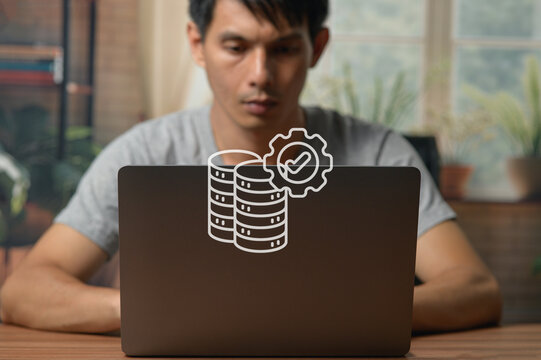 Young Man Working on Laptop with Technology Icon Overlay in Indoor Setting