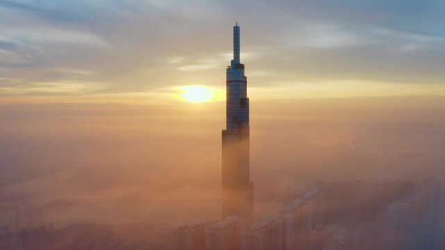 Aerial drone view of Landmark 81 rising above morning fog at sunrise in Ho Chi Minh City Vietnam