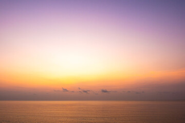 Fototapeta premium nature sky breathtaking golden sunset over a calm ocean, with the entire sky and water bathed in brilliant shades of yellow and orange. Streaky clouds enhance the dramatic display 