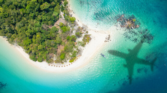 Aerial view of shadow passenger plane silhouette and sandy beach blue sea with waves at sea beach summer vacation sea travel concept	
