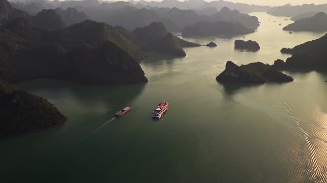 Cruise Ship And Barge Navigating On The Ha Long Bay At Dusk In Vietnam. - aerial shot