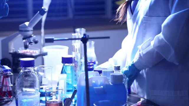 Female researcher's hands mixing solution through pipette at chemistry lab