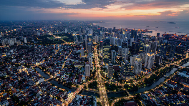 Jakarta Aerial Cityscape at Sunset, Business District Skyscrapers with Monas Monument, Java Sea Horizon and City Highway Lights, Indonesia Drone Photography