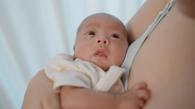 Newborn Embrace: A tender moment captured as a mother cradles her newborn baby, highlighting the pure innocence and unconditional love shared between parent and child.