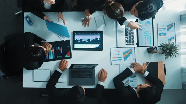 Top view of smart business people brainstorm marketing idea at meeting table while compare stock market investment data between laptop and tablet. Business team planning financial plan. Directorate.