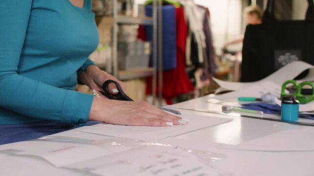 Dressmaker drafter. Fashion creation. Designer drawing paper pattern with professional tailor tool. Woman measuring apparel model with curve ruler.