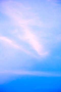Vertical Minimalist Blue Sky with Soft Pinkish Clouds
