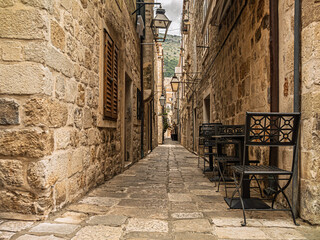 Fototapeta premium Narrow Medieval Stone Alley With Tables And Chairs