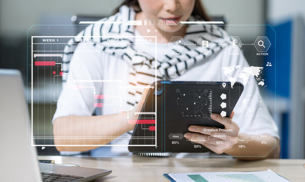 Businesswoman hand Project manager working and update tasks and Gantt chart scheduling virtual diagram.with smart phone, tablet and laptop in office.