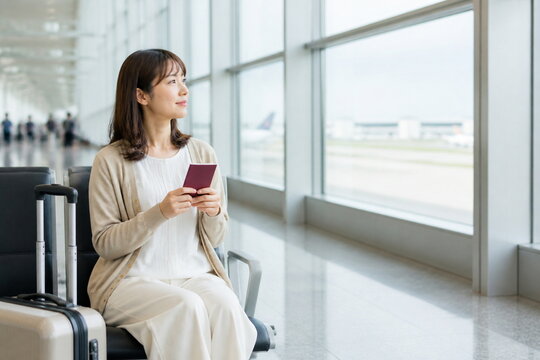 空港待合席で旅行書類を確認する女性