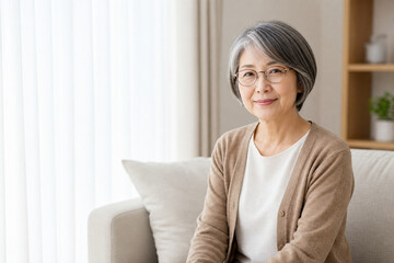 Fototapeta premium 明るいソファで微笑む眼鏡のボブ女性