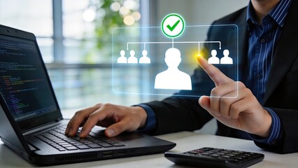 Fototapeta premium Man using laptop with holographic interface showing verified user icon and team structure, digital identity confirmation, secure login concept, network management