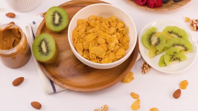 Hand Adding Fresh Blueberries to Healthy Corn Flakes Breakfast Bowl