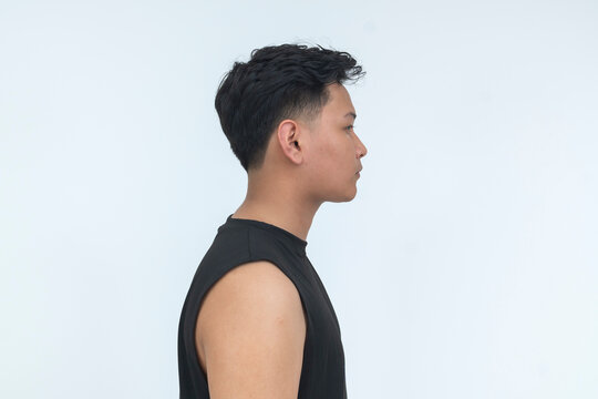 Chest-up side profile portrait of a serious young Filipino man in black sleeveless clothing, isolated on a white background.