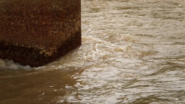 大雨で増水し激しく流れる茶色の濁流（災害・防災・気象）