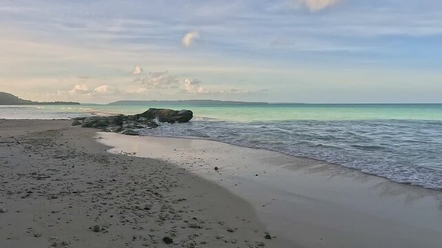 Serene Tropical Beach Landscape with Turquoise Ocean Waves Crashing on Rock Formation