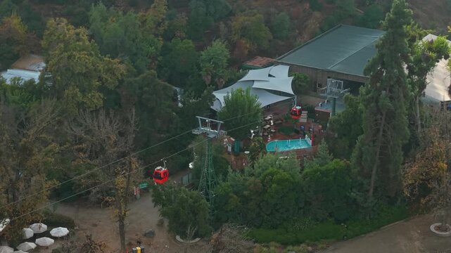 Telephoto aerial orbit of the departure station of the Santiago cable car on San Cristobal Hill, Chile, a tourist transportation system