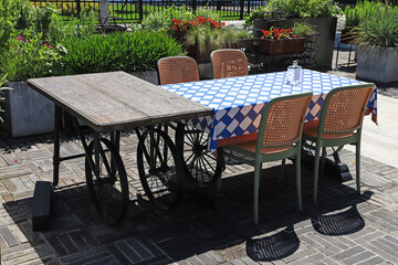 Obraz premium Outdoor leisure dining set with vintage wheel table in garden courtyard