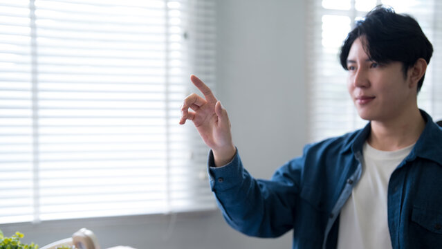 Young Asian man pointing gesture presenting idea during creative work meeting in bright modern office space