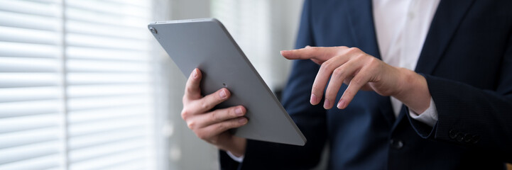 Professional in formal suit using digital tablet for business task at modern office workspace © snowing12
