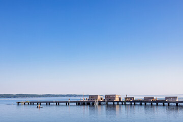 Fototapeta premium Jetty with people in a lake a beautiful sunny summer day
