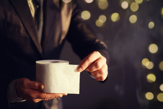 Businessman Holding a pile of Toilet Paper, copy space. Toilet papers is the new currency concept.