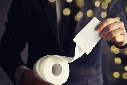 Businessman Holding a pile of Toilet Paper, copy space. Toilet papers is the new currency concept.