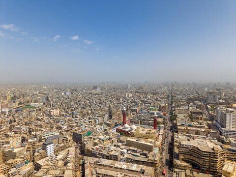 Aerial view of the dense urban landscape featuring the prominent I.I. Chundrigar Road, historic buildings, and a mosque with red minarets in Karachi, Sindh, Pakistan.