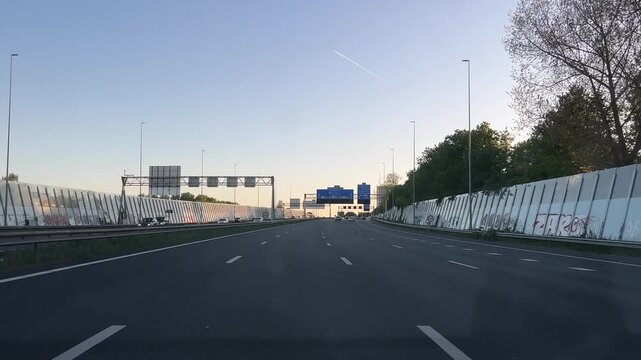 Amsterdam Netherlands highway, Curving multi lane highway with noise barriers at dusk